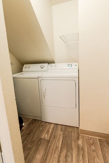 a white washer and dryer in a room with wood floors